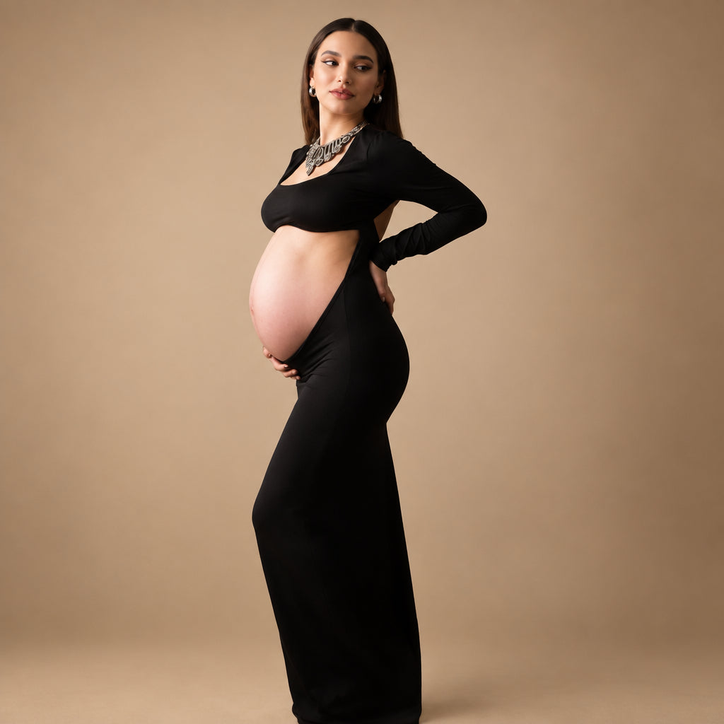 Pregnant woman in a black dress against a textured gray background