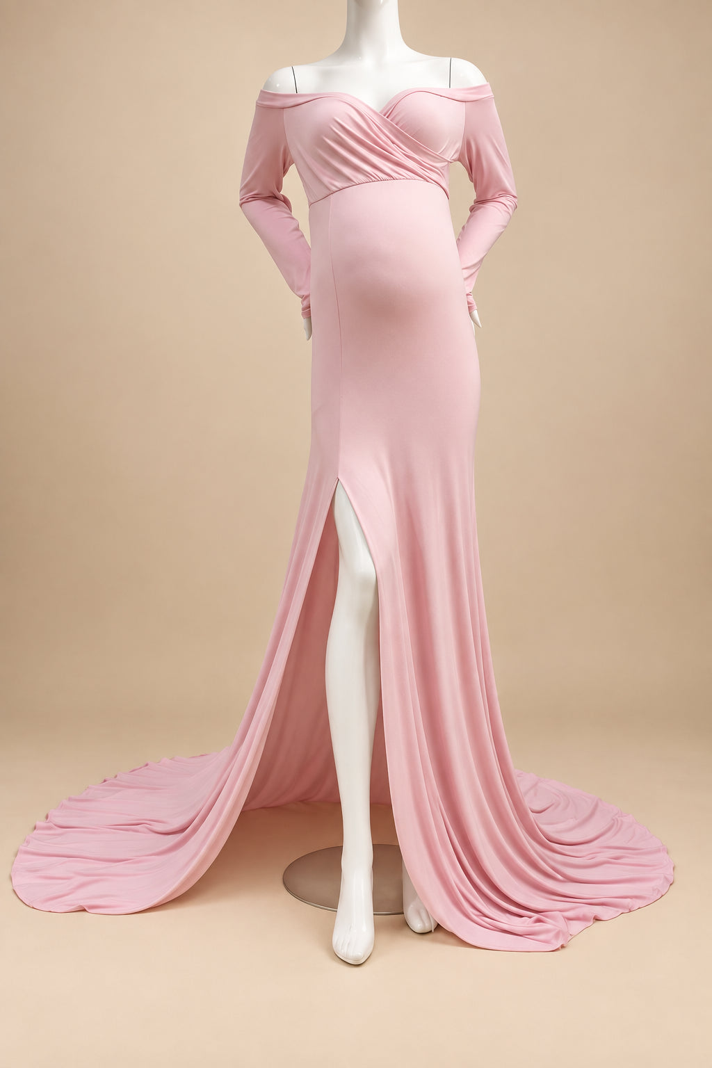 A light pink off-the-shoulder maternity gown with long sleeves, a sweetheart neckline, and a thigh-high slit, displayed on a white mannequin with a long train on a cream shag rug.