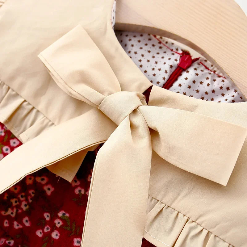 Close-up of a beige garment with a bow detail on a floral background