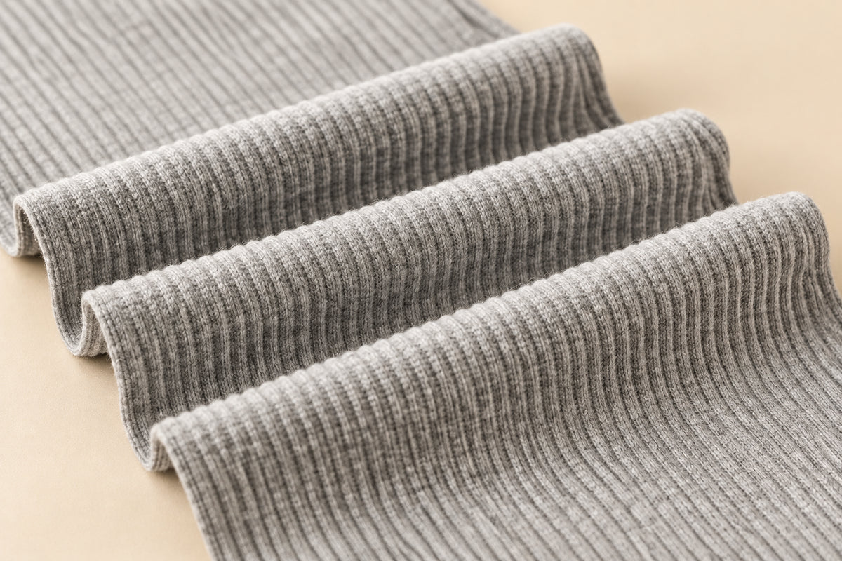 Stack of gray ribbed fabric on a white background