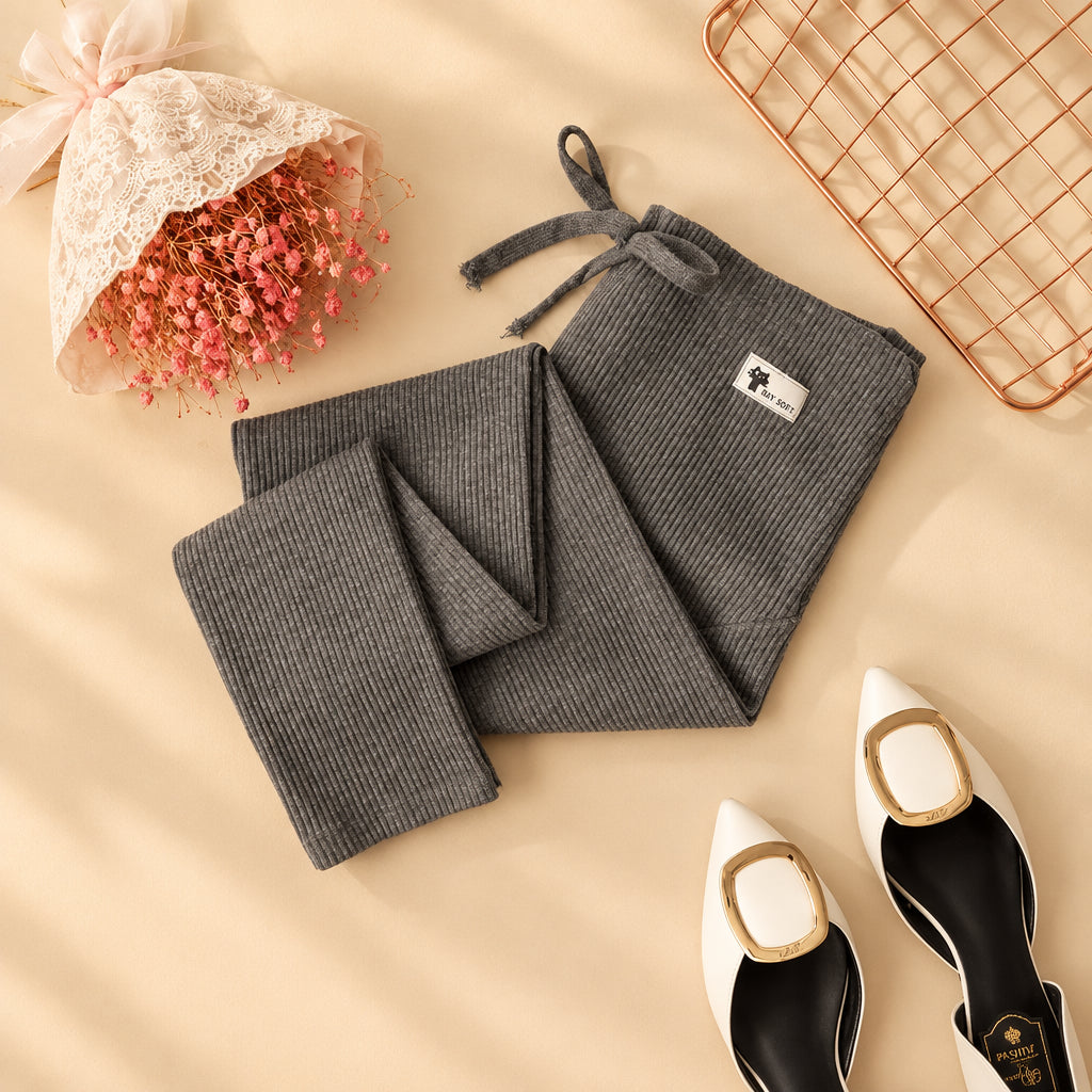 Gray kitchen towel set with a brand label on a white surface with decorative items.