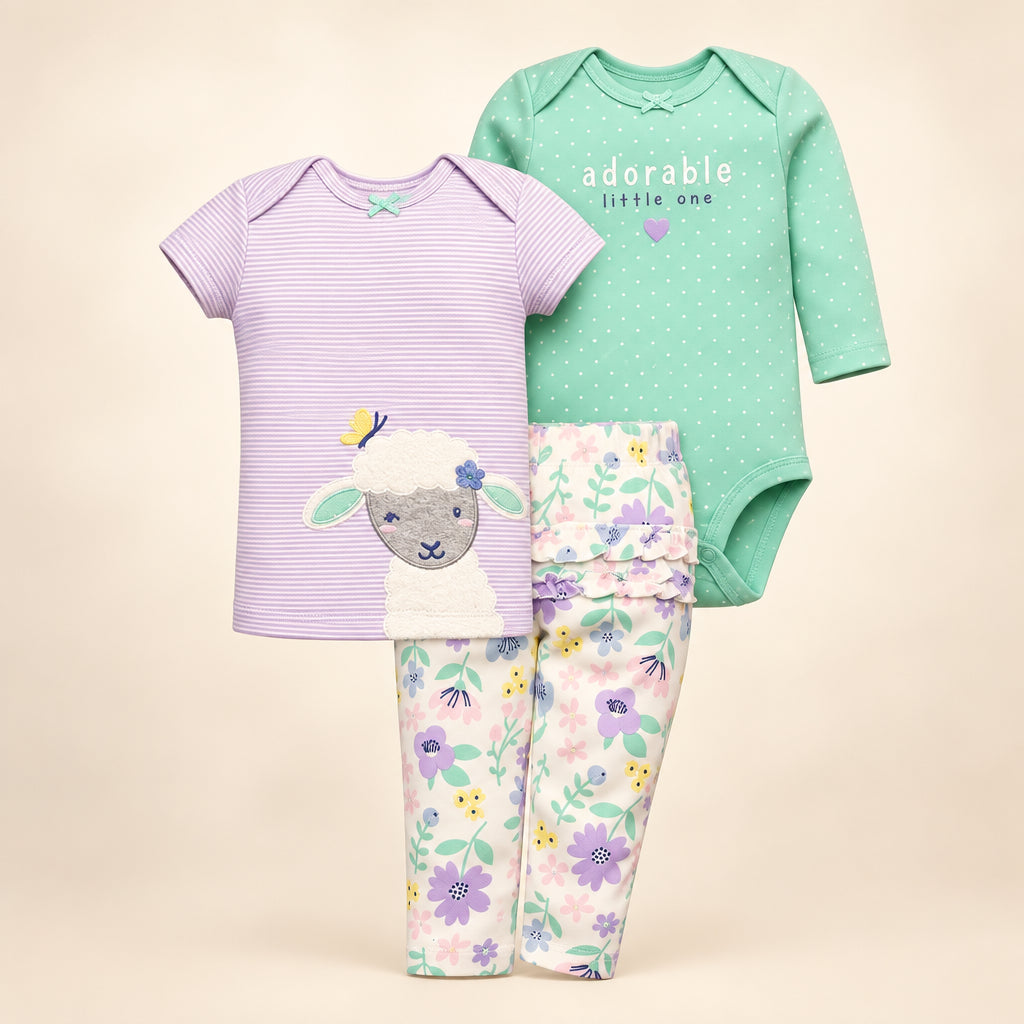Set of baby clothing including a onesie, t-shirt, and pants on a white background