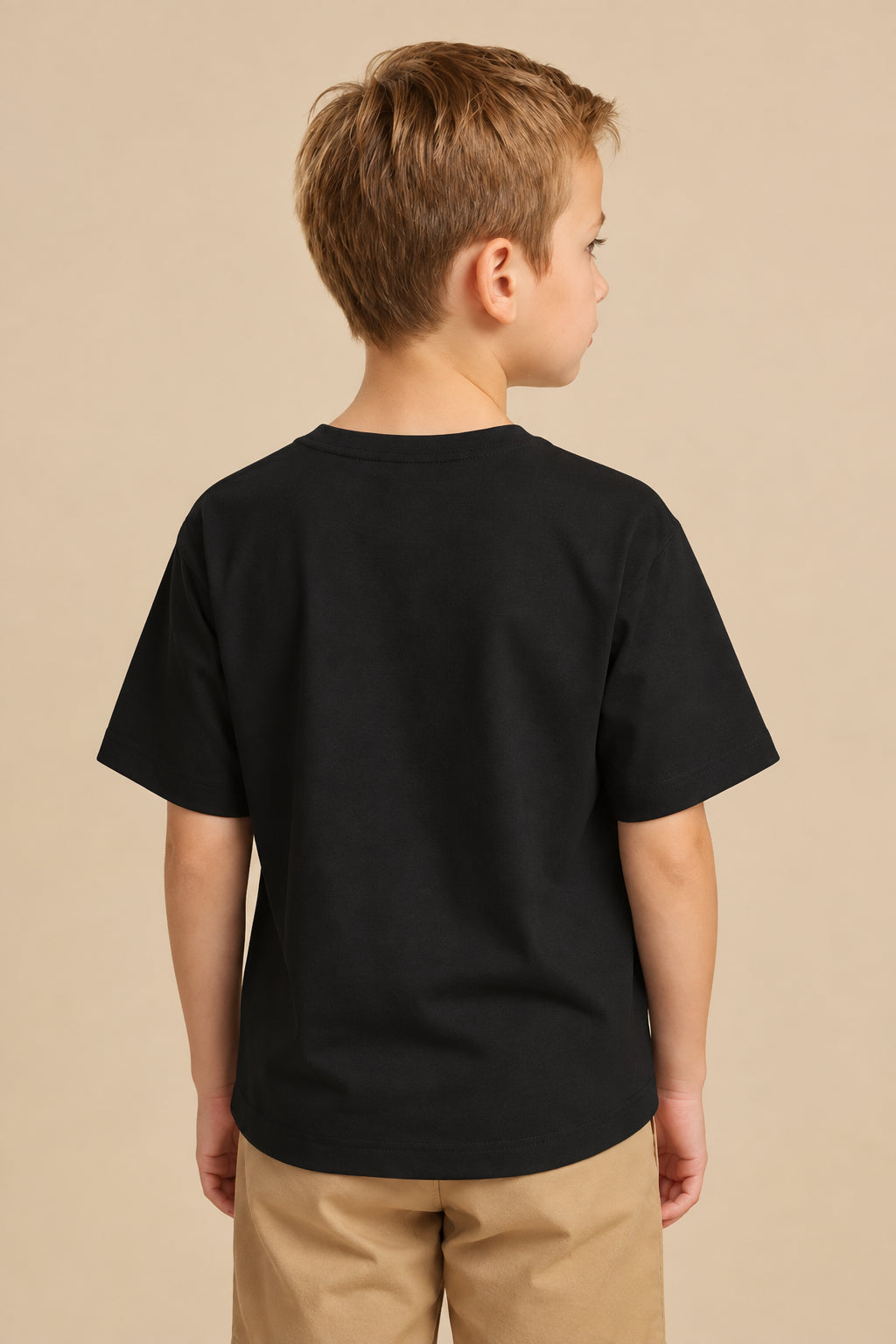 Child wearing a black t-shirt on a plain background