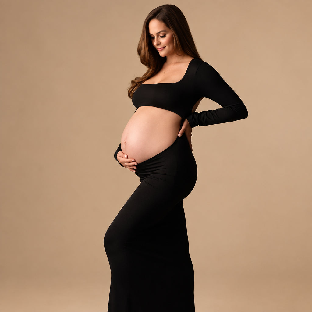 Pregnant woman in a black outfit against a gray background